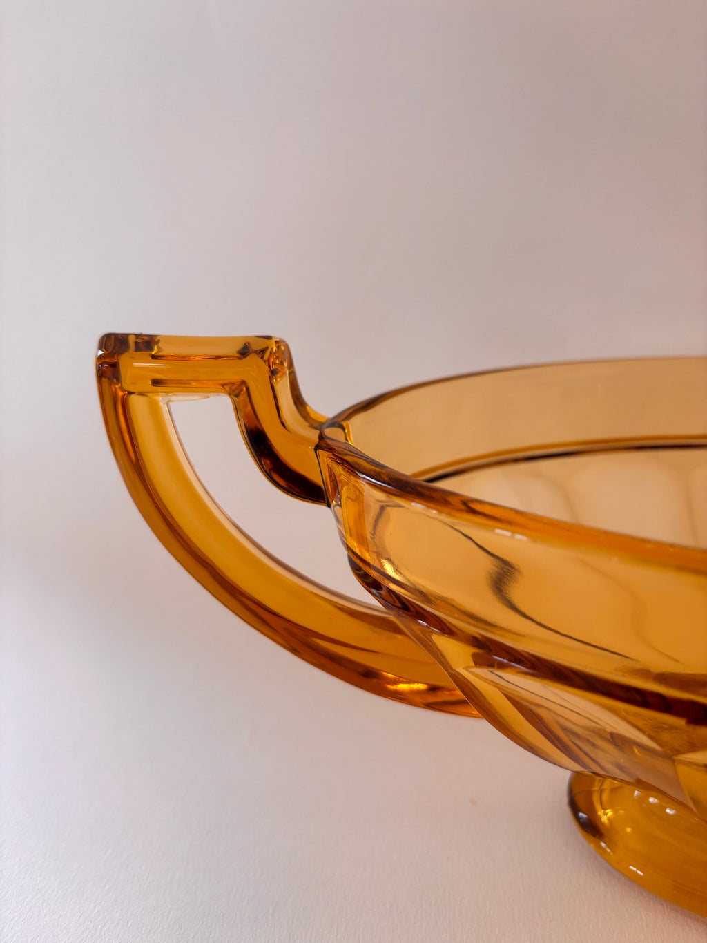 Close-up of angular handles on a vintage Val Saint Lambert amber glass Art Deco coupe