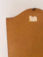 Back of a vintage arched wall mirror showing hanging hardware and frame construction