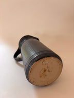 underside of a vintage stoneware jug showing artist signature inscribed in clay