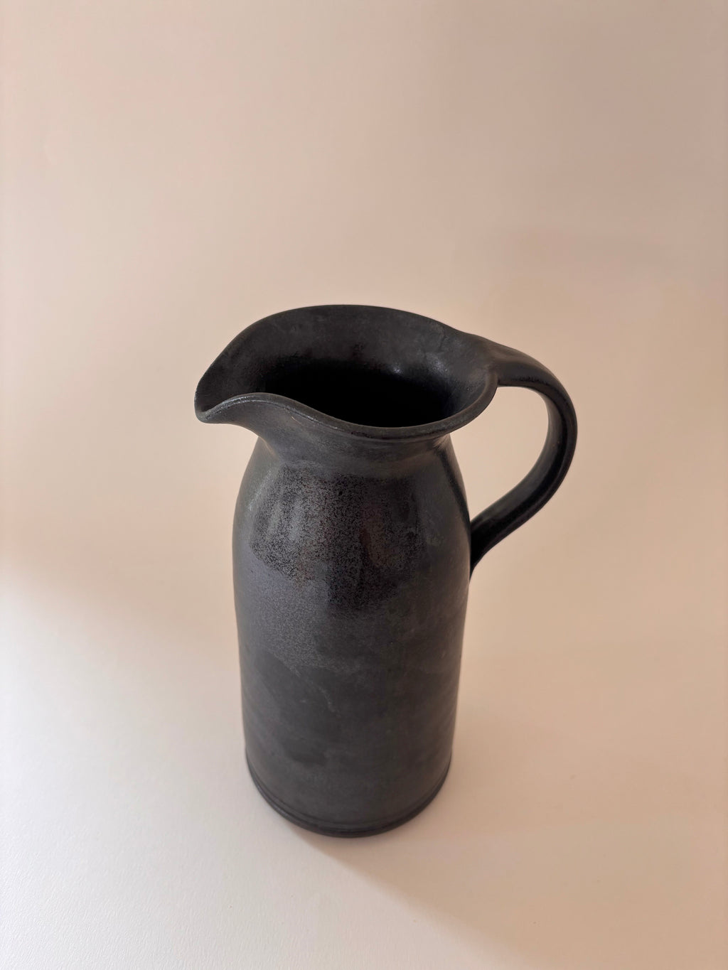 Front view of a black glaze vintage stoneware jug