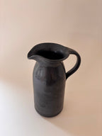 Front view of a black glaze vintage stoneware jug