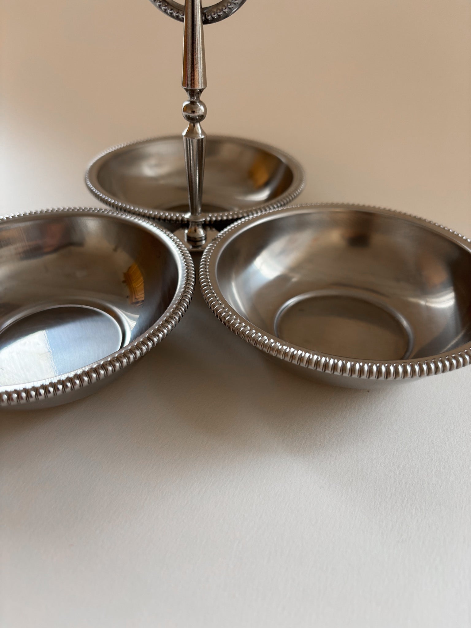 Close-up of beaded edge detail on a vintage Jean Couzon stainless steel serving bowl