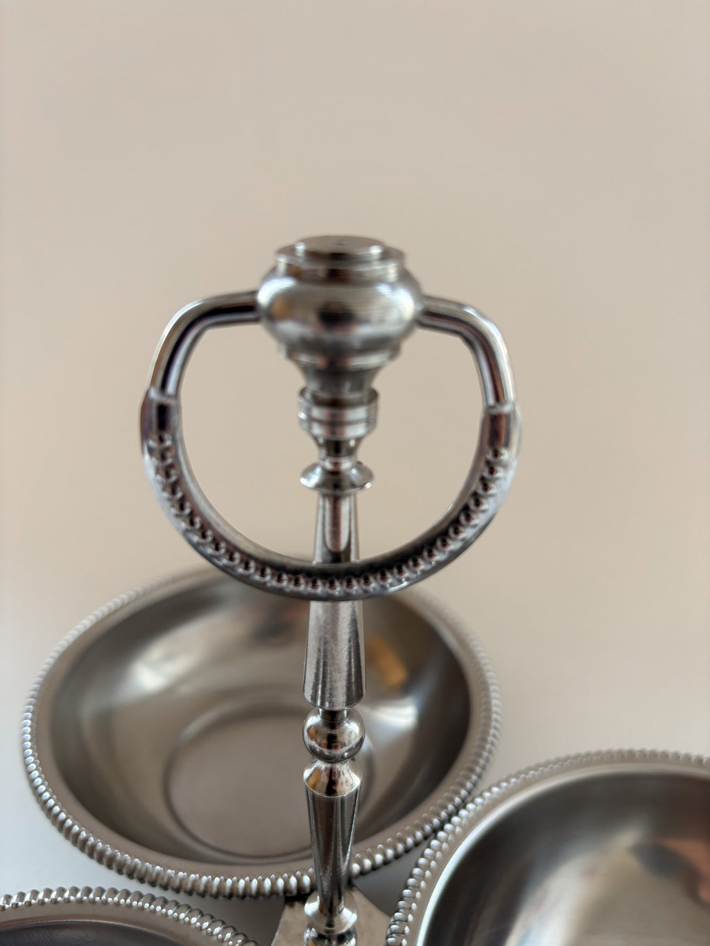 Close-up of the central loop handle on a vintage Jean Couzon three-compartment server