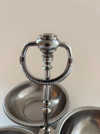 Close-up of the central loop handle on a vintage Jean Couzon three-compartment server