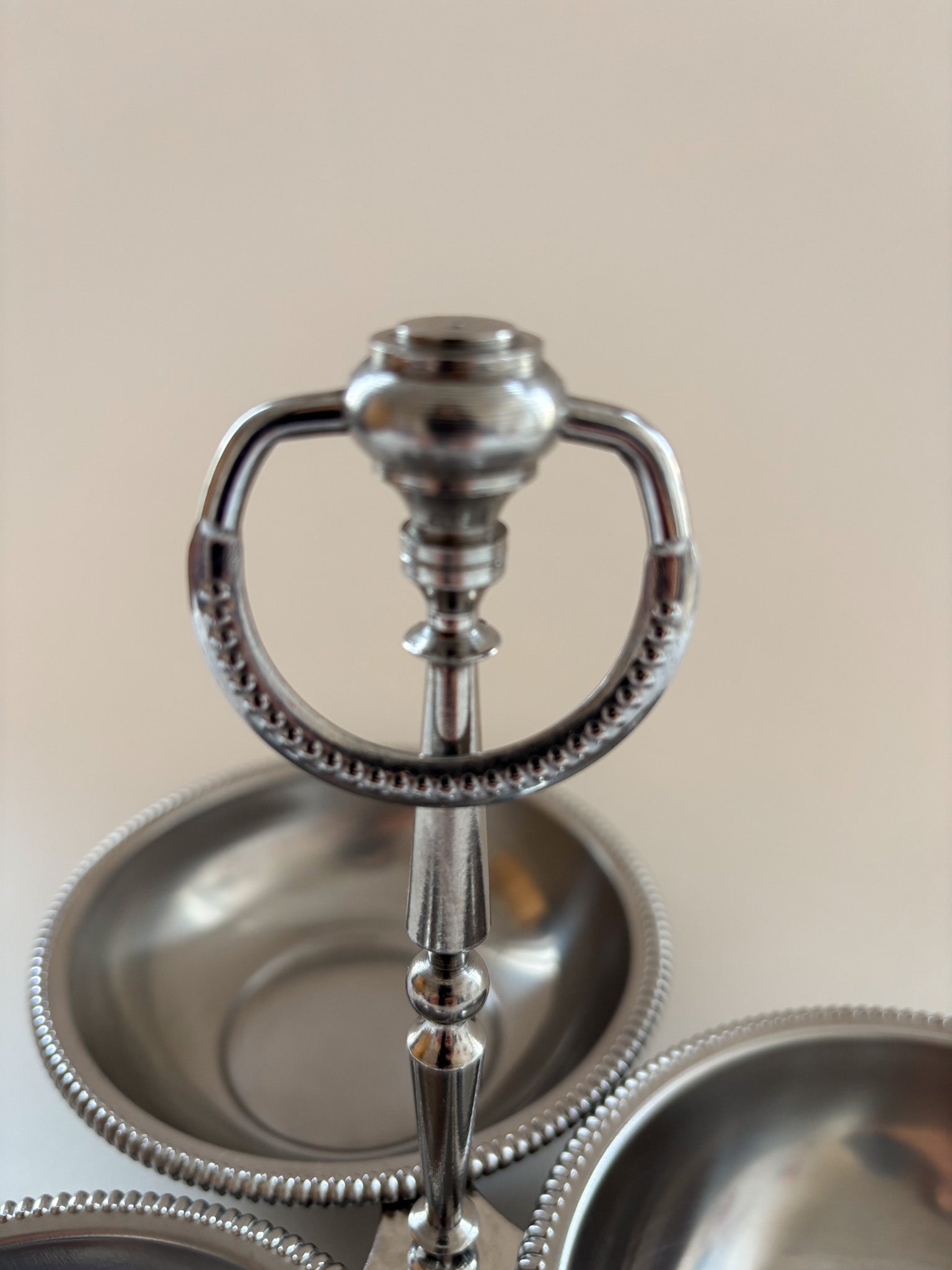 Close-up of the central loop handle on a vintage Jean Couzon three-compartment server