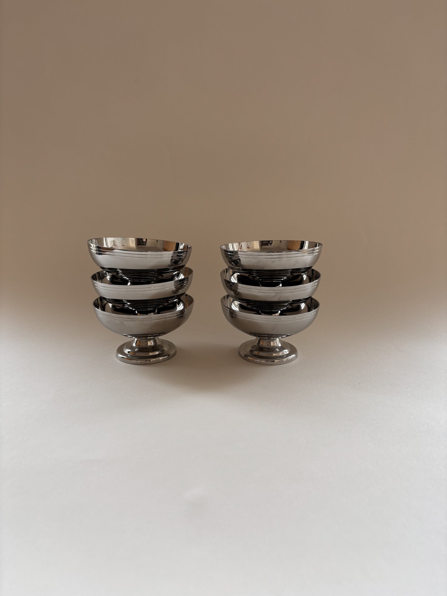 Set of six vintage stainless steel dessert cups by L'Étang & Rémy stacked together.