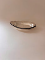 Vintage silver-plated oval dishes stacked together.