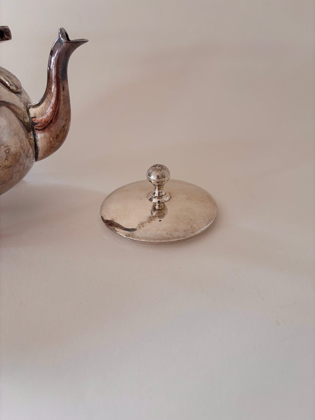 vintage silver-plated teapot showing lid, spout and patina detail