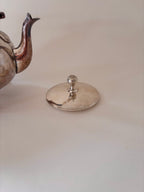 vintage silver-plated teapot showing lid, spout and patina detail
