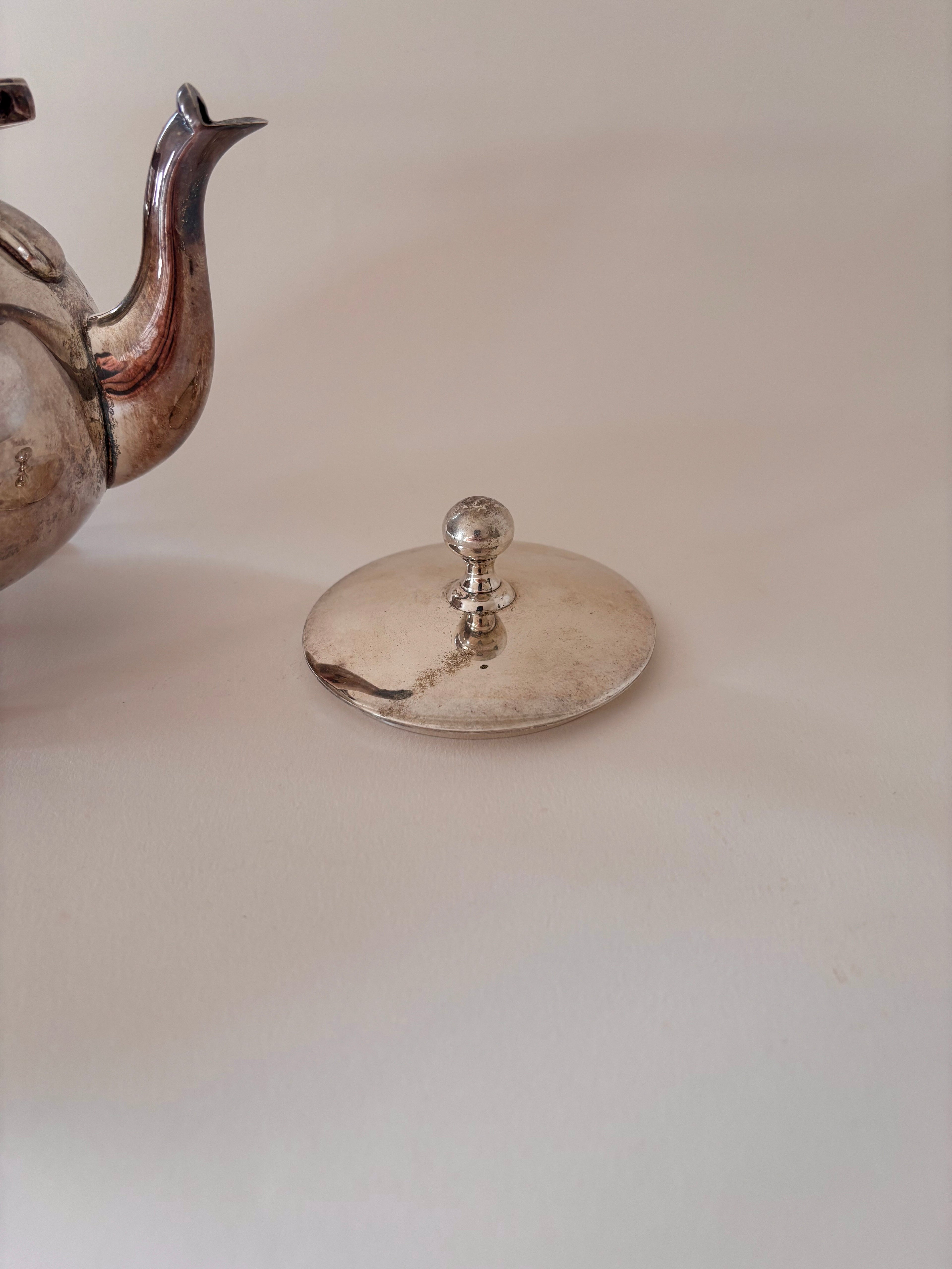 vintage silver-plated teapot showing lid, spout and patina detail