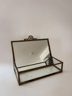 Front view of vintage brass and glass vanity box with ornamental detailing