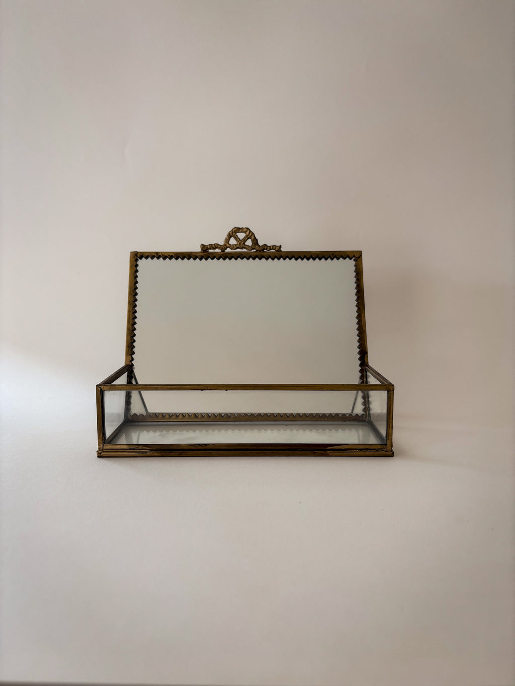 Mirrored upper panel of vintage brass and glass vanity box