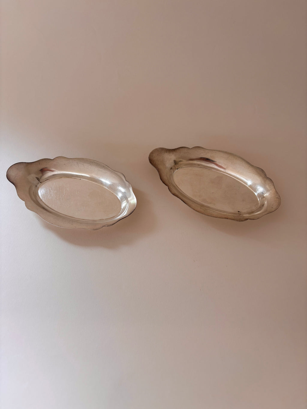 Set of vintage silver-plated oval dish with scalloped edges seen from above.