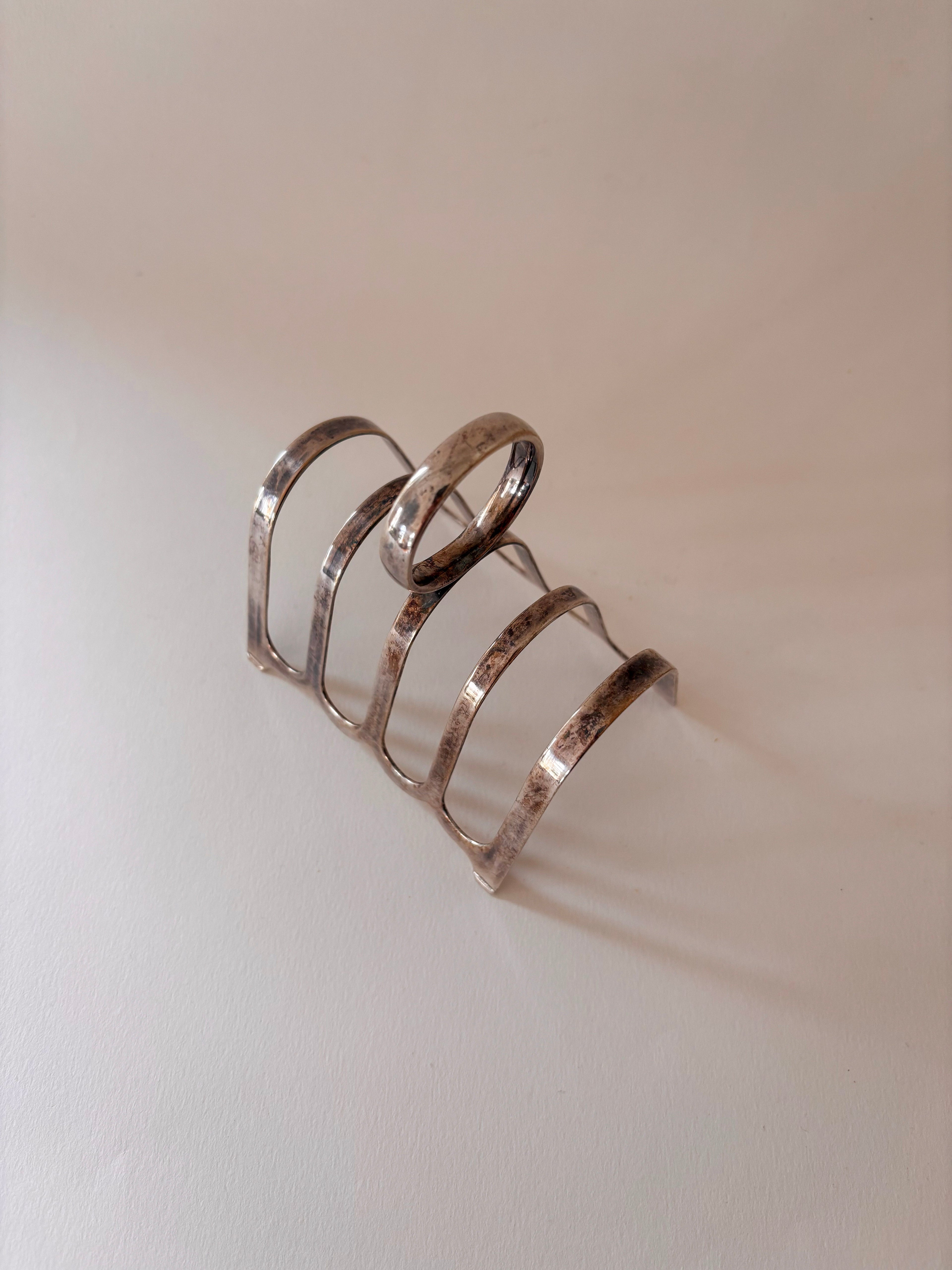 silver-plated toast rack showing arched slots and loop handle detail